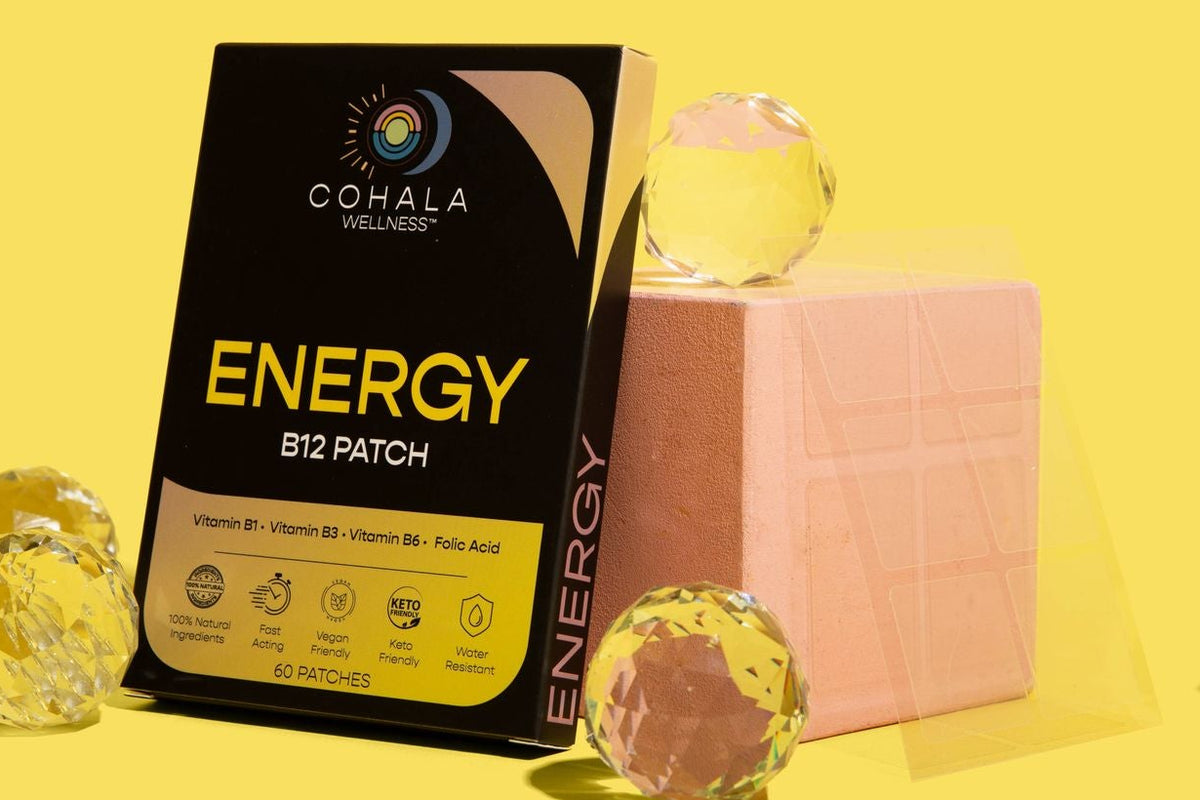 COHALA Wellness Energy B12 Patch box beside a pink block and glass spheres on a yellow background